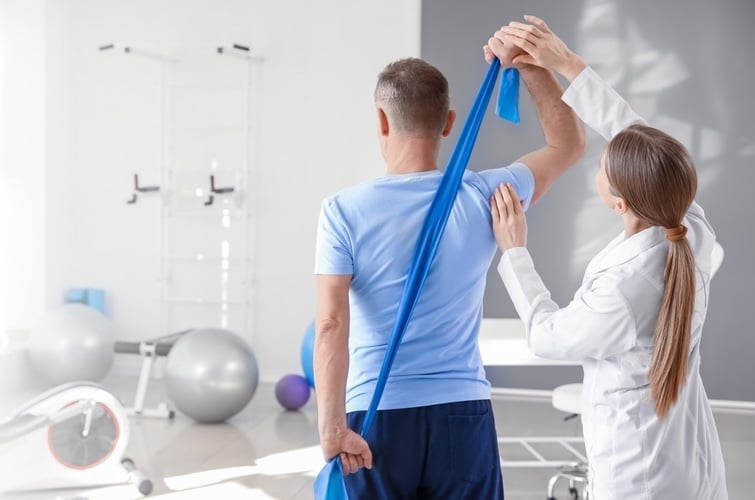 Physiotherapist working with mature patient in rehabilitation center